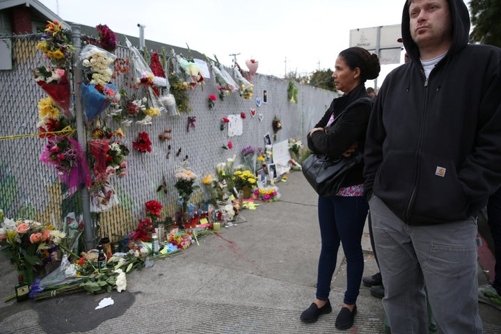 People view a sidewalk memorial near the burned Oakland warehouse on Dec. 5, 2016.