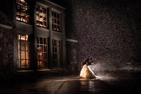 The night sky and a street lamp combine to shine a spotlight of dramatic snowfall on this couple, making for a magical shot.