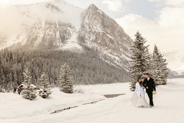 <p>A cozy lodge in the background adds an element of warmth to this magical and chilly scene. This couple really is walking in a winter wonderland.</p>