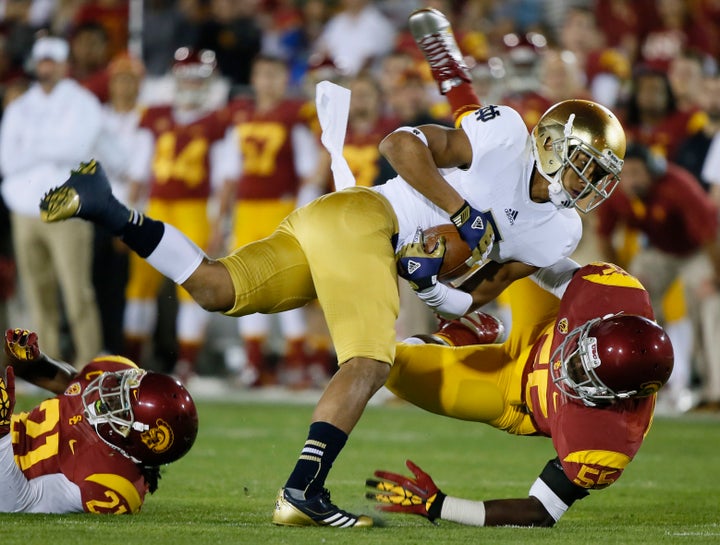 Notre Dame wide receiver T.J. Jones is brought down by USC's Lamar Dawson at the Coliseum in Los Angeles on Nov. 24, 2012. Dawson sued USC, the PAC-12 conference and the NCAA in September, claiming they had violated federal wage and hour laws.