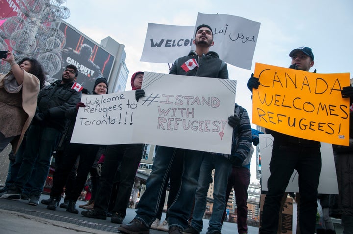 People take to the streets in Toronto on Nov. 22, 2015 with banners and signs rejecting Islamophobia and welcoming refugees.