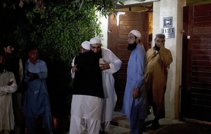 Relatives and friends of Pakistani singer-turned Islamic preacher Junaid Jamshed, comfort each other outside his home following reports he died in plane crash