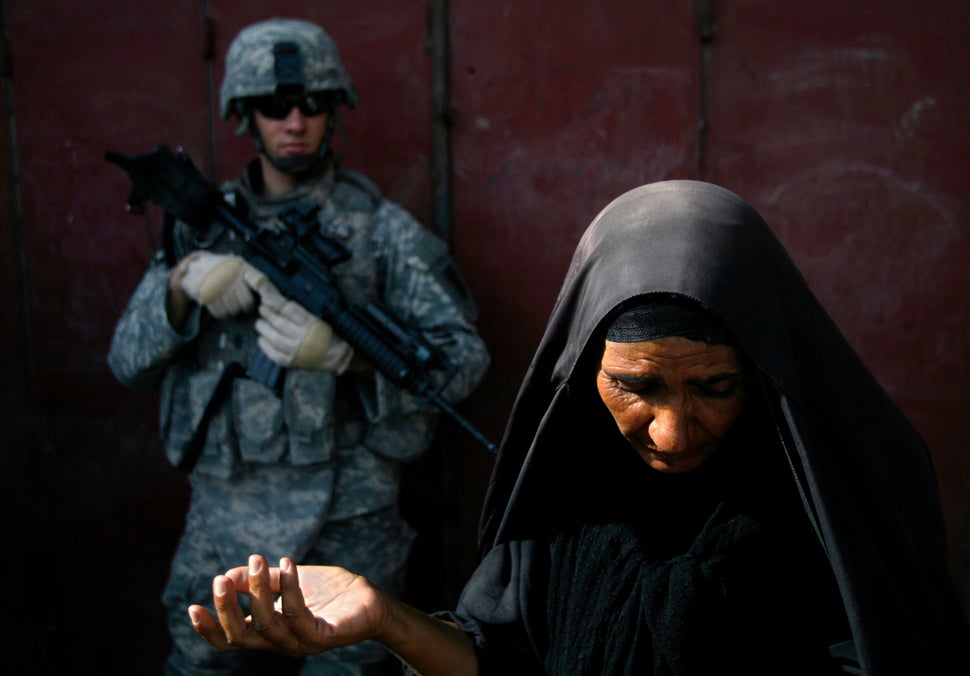 An Iraqi woman tries to explain to American soldiers that she had nothing to do with illegal fuel sellers in Baghdad on Aug.