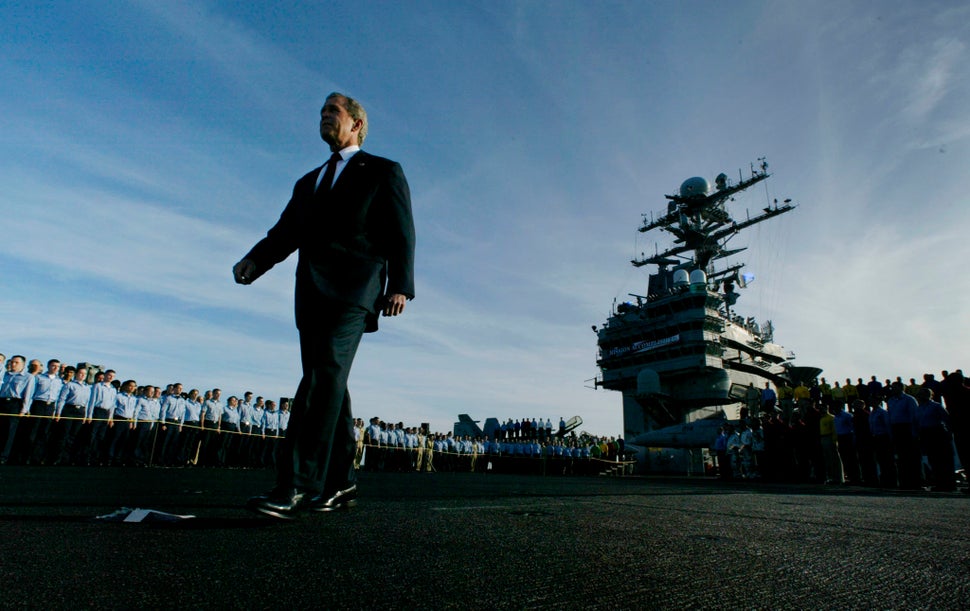 Bush passes crew members as he walks the deck of the aircraft carrier USS Abraham Lincoln, on May 1, 2003, just before his "m