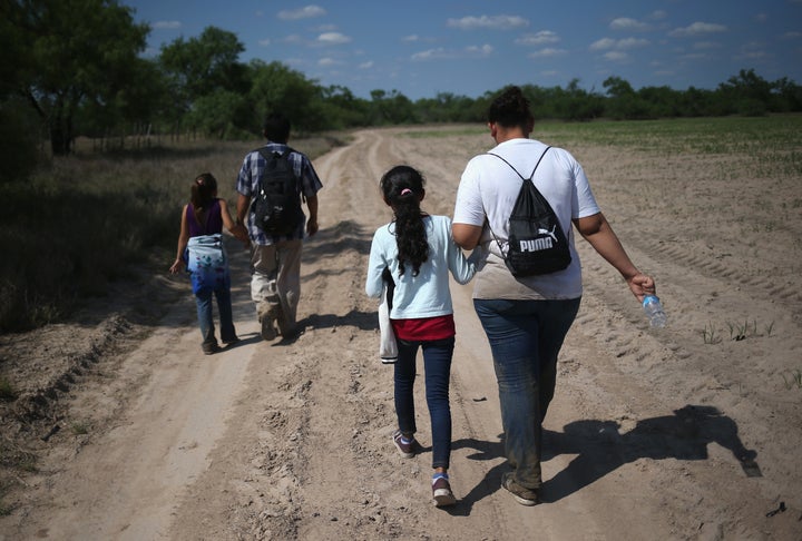 Central American immigrant families walk through the countryside in Roma, Texas, in April after crossing from Mexico into the United States to seek asylum. Customs and Border Protection will open a new temporary shelter to handle an influx of migrants on Friday.