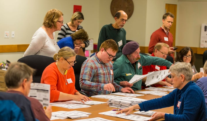 Designated observers watch tabulators recount presidential ballots in Madison, Wis., on Dec. 1, 2016.