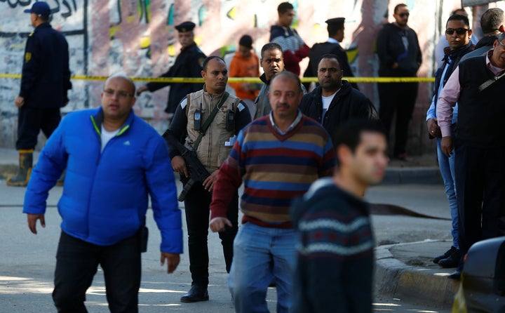 Plain clothes police officers stand guard at the scene of a bomb blast in Giza Al Haram Street on the outskirts of Cairo, Egy