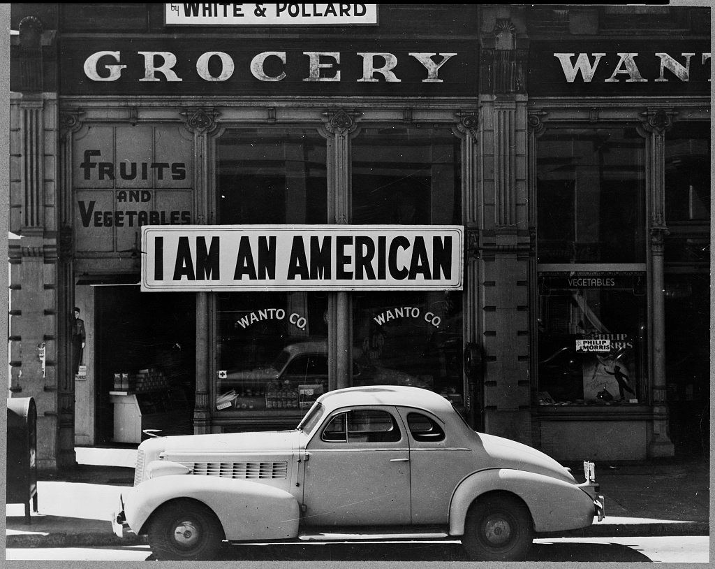 A large sign reading "I am an American" placed in the window of a store on the day after Pearl Harbor. The store was closed following orders to persons of Japanese descent to evacuate from certain West Coast areas. The owner was a University of California graduate.