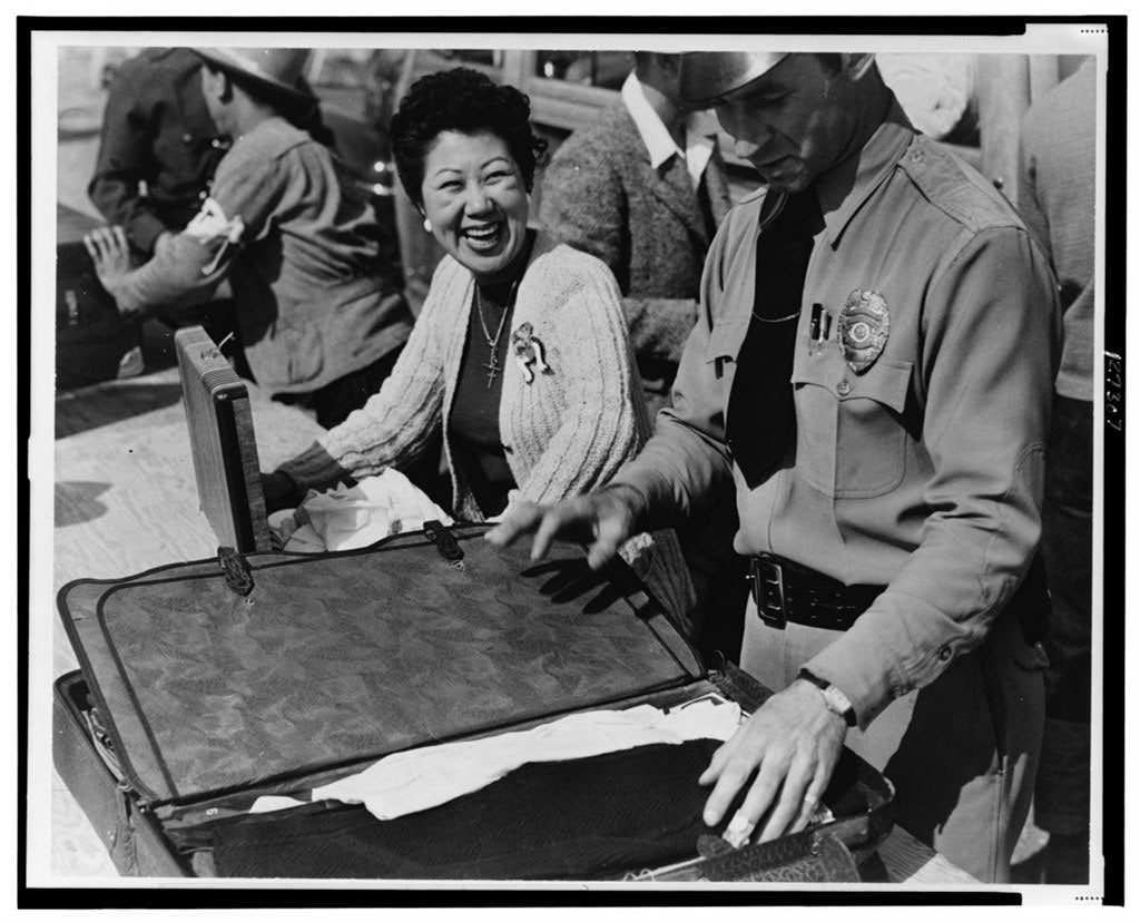 An officer inspecting a woman's suitcase.