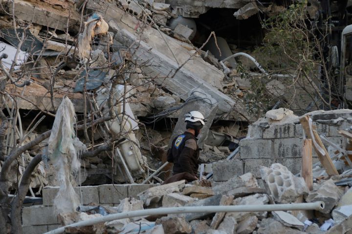 A rescue worker searches the debris of a collapsed hospital in Idlib Province on Feb. 15, 2016.