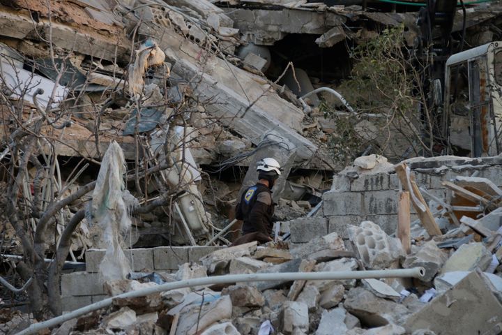 A rescue worker searches the debris of a collapsed hospital in Idlib Province on Feb. 15, 2016.