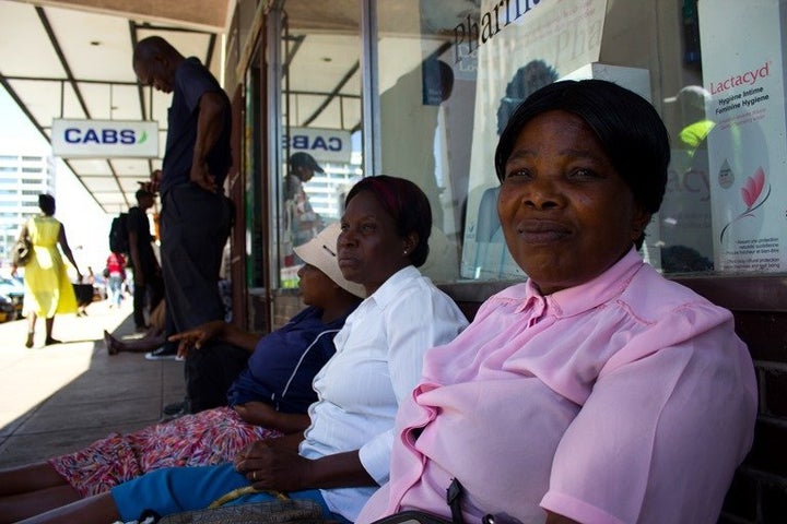 Siphiwe Esiphakathi sits with other women in a queue outside a bank in Bulawayo, Zimbabwe, hoping to get access to their cash. For many women, waiting for hours to get money in the midst of the country's cash shortage means skipping doctors' appointments or essential treatments.