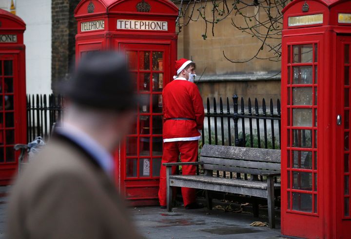 Man dressed as Santa Claus relieves himself.
