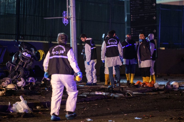 Turkish forensic police officers work on the site where a car bomb exploded near the stadium of football club Besiktas