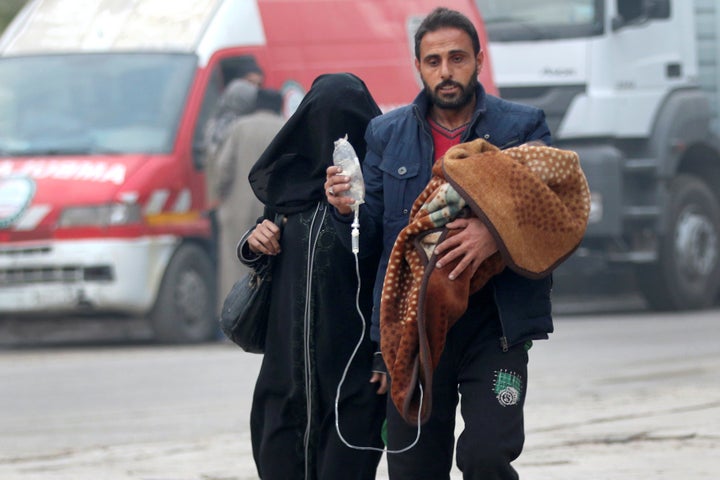 A man carries a child with an IV drip in Aleppo, Syria, on Dec.12, 2016.