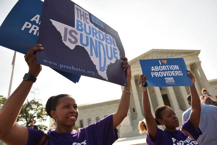 Abortion rights activists hold placards outside of the U.S. Supreme Court ahead of an expected ruling on abortion clinic restrictions on June 27, 2016.