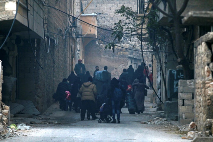 People carry belongings as they flee deeper into the remaining rebel-held areas of Aleppo