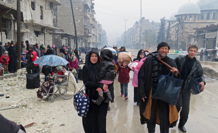 Syrian residents, fleeing violence in the restive Bustan al-Qasr neighbourhood, arrive in Aleppo's Fardos neighbourhood