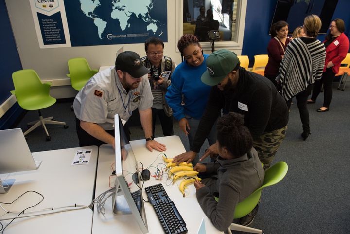 A Teen Tech Center student Alternatives in Action employee and Best Buy Geek Squad Agent explore one of its many tech stations which allows students to play musical keys like a piano from bananas