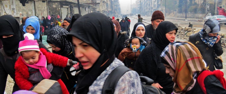 Syrian residents, fleeing violence in the restive Bustan al-Qasr neighborhood, arrive in Aleppo's Fardos neighborhood on Tuesday.