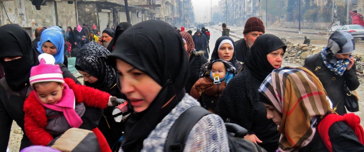 Syrian residents, fleeing violence in the restive Bustan al-Qasr neighborhood, arrive in Aleppo's Fardos neighborhood on Tuesday. 