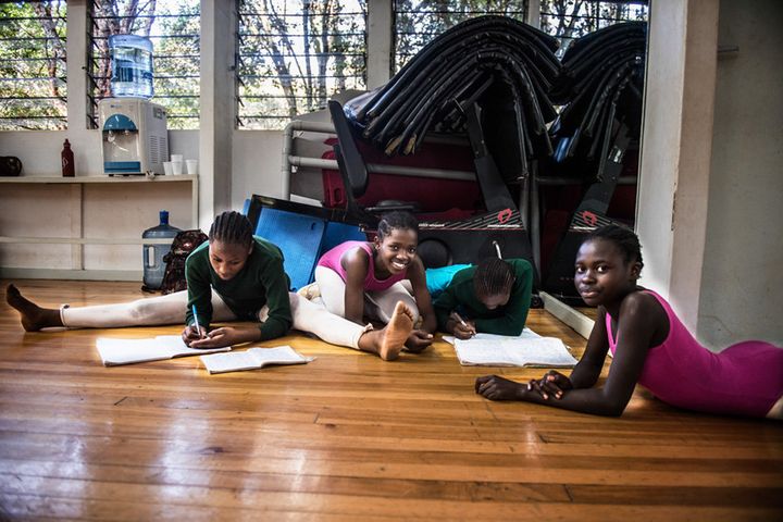 The dancers do homework in between classes to keep up their grades. They know that good grades and dance are two things that can take them out of Kibera one day.