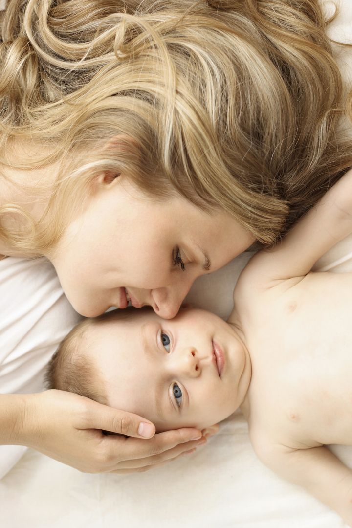 Mother and baby relaxing in the bed damircudic via Getty Images