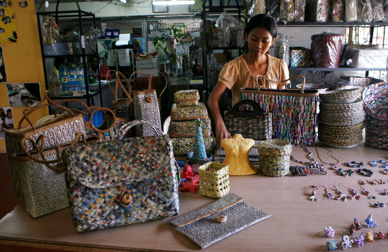 One of the slum dwellers displays handbags and shoulder bags, made from newspapers, magazines and telephone book directory
