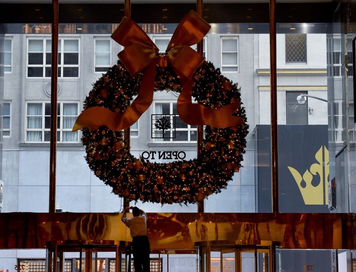 Workers hang a Christmas wreath at Trump Tower on another day of meetings for President-elect Donald Trump November 22, 2016 in New York.