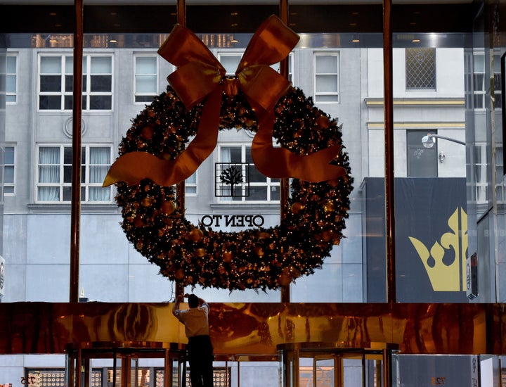 Workers hang a Christmas wreath at Trump Tower on another day of meetings for President-elect Donald Trump November 22, 2016