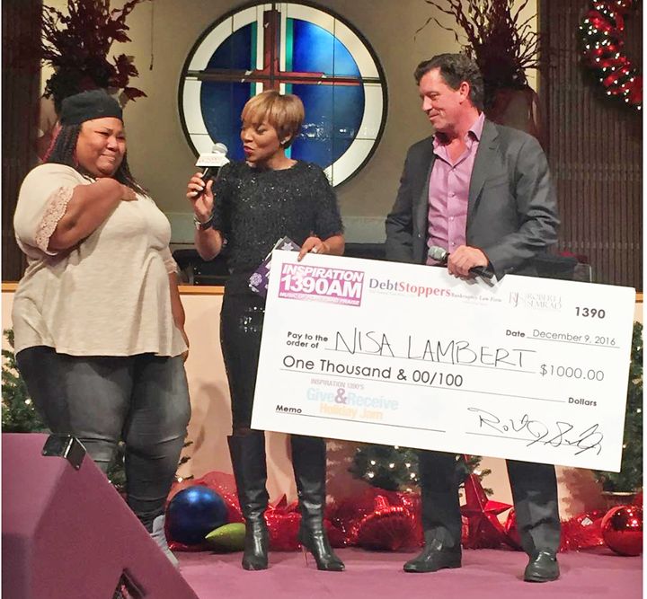 Robert Semrad presents a check for $1,000 to help a Chicago South Side resident buy furniture for the new home she received thanks to charitable giving.