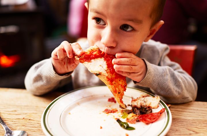 Boy eating pizza ballyscanlon via Getty Images