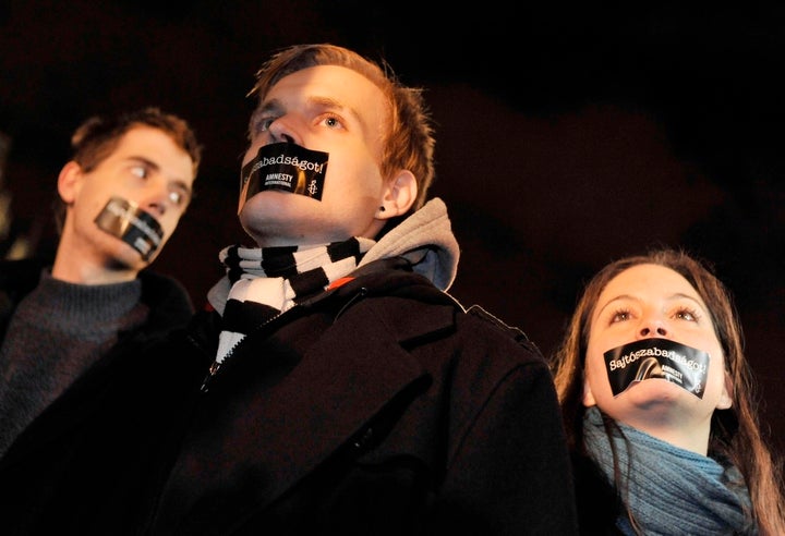 Hungarian Amnesty International activists protest with taped mouth during a demonstration against the government’s new media law in Budapest in 2011. The message, in Hungarian, reads “We want press freedom!”