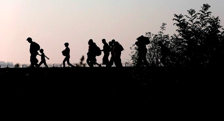 Migrants walk along the railway track after crossing the border between Serbia and Hungary on Sept. 13, 2015.