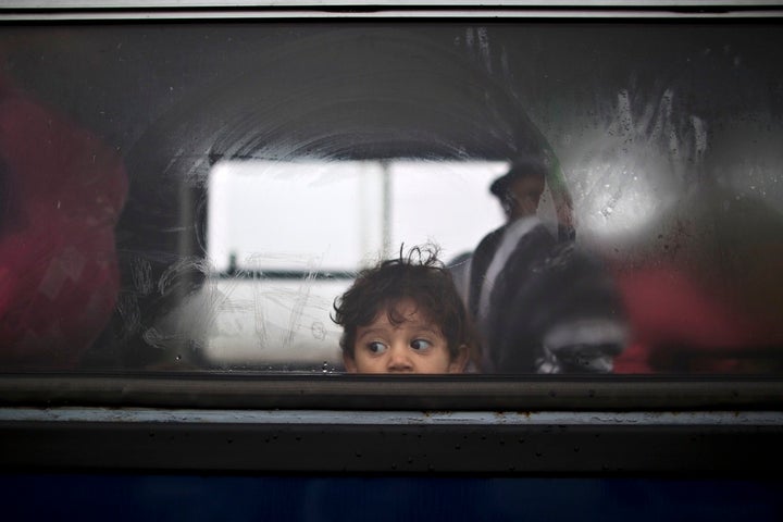 A Syrian refugee child looks out of a bus that will take him and his family to the center for asylum seekers in southern Hungary.