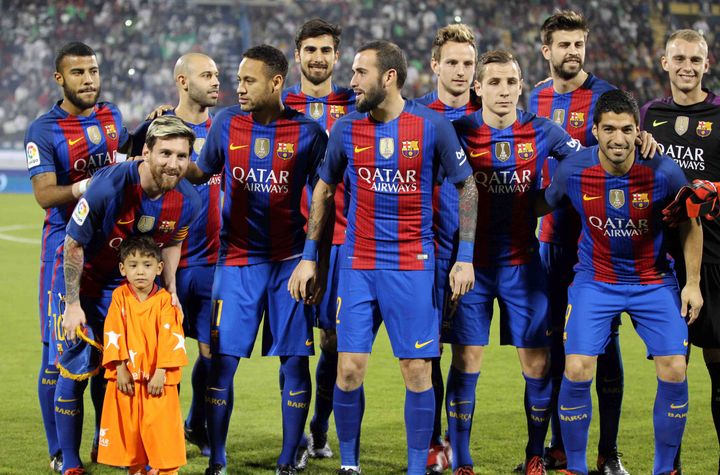 Lionel Messi (second from left) and the FC Barcelona team pose for photos with Murtaza Ahmadi before a match.