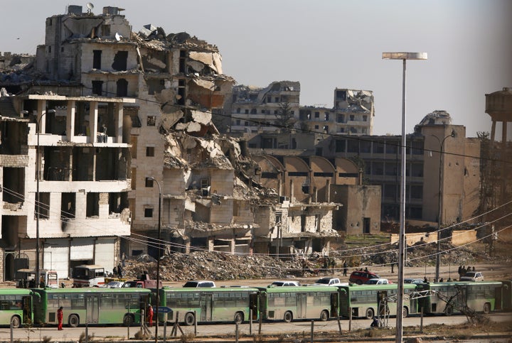 Buses are seen parked in Aleppo's government controlled area of Ramouseh, as they wait to take civilians and rebels from eastern Aleppo on Thursday.