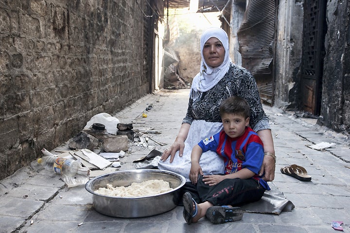 Jdaideh, Aleppo. A displaced mother tends to her child and bakes bread.