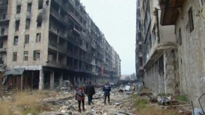 People walked through the destroyed streets of Aleppo on December 13.