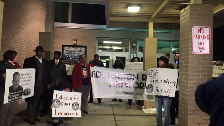 Image of a group of protestors outside of a school building holding signs to show solidarity to the injustice committed to a disabled student.