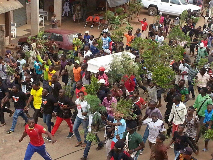 Demonstrators in Buea walk a coffin of a murdered civilian.