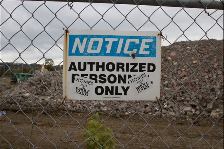 The rubble from homes demolished in East Liberty to make way for Whole Foods. The “authorized personnel only” sign on a chain link fence is covered in stickers that say “Homes Not Whole Foods.”
