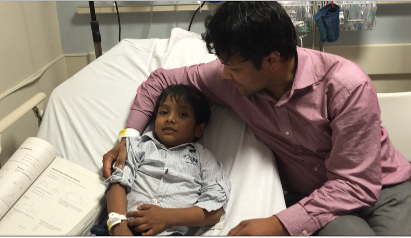Two-year-old Isaac was lying on a hospital bed, suffering from a fever. I was sitting on the chair next to his bed. I held hi
