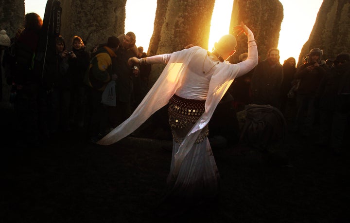 People gather for sunrise during winter solstice at Stonehenge in Wiltshire