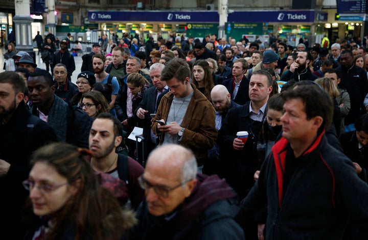 Passengers queue for a reduced during the Southern railway strike at Victoria station in London.