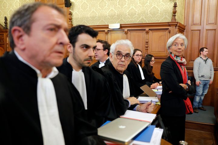 Managing Director of the International Monetary Fund (IMF) Christine Lagarde (R) stands with her lawyers before the start of her trial.