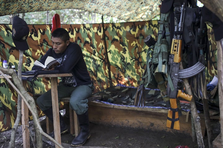 A FARC guerrilla reads a book at a camp near Conejo in northern Colombia on Dec. 6.