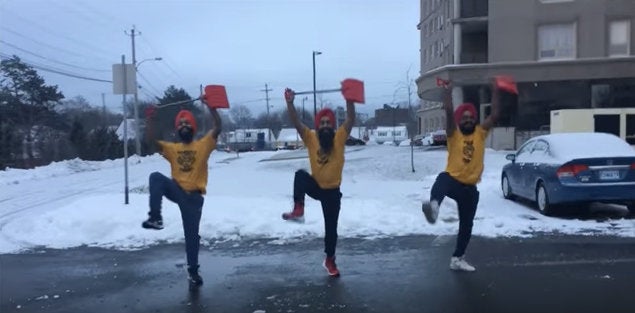 Members of the Maritime Bhangra Group perform bhangra in a parking lot.