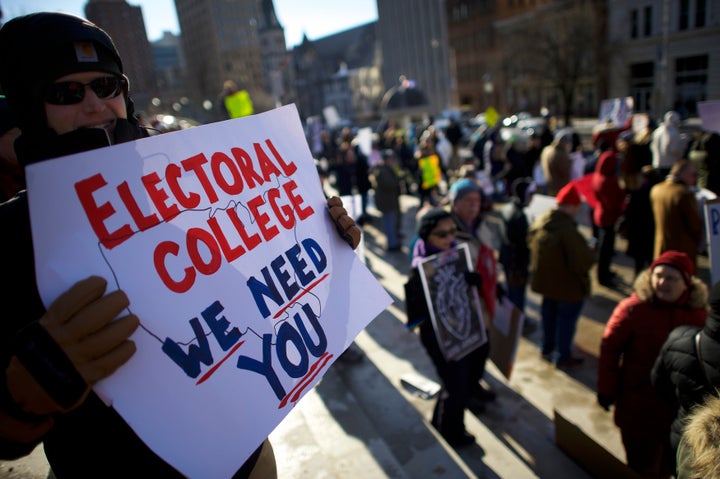 Protesters rally against President-elect Donald Trump Monday outside the Pennsylvania State Capitol Building in Harrisburg before Electoral College members cast their votes for president.