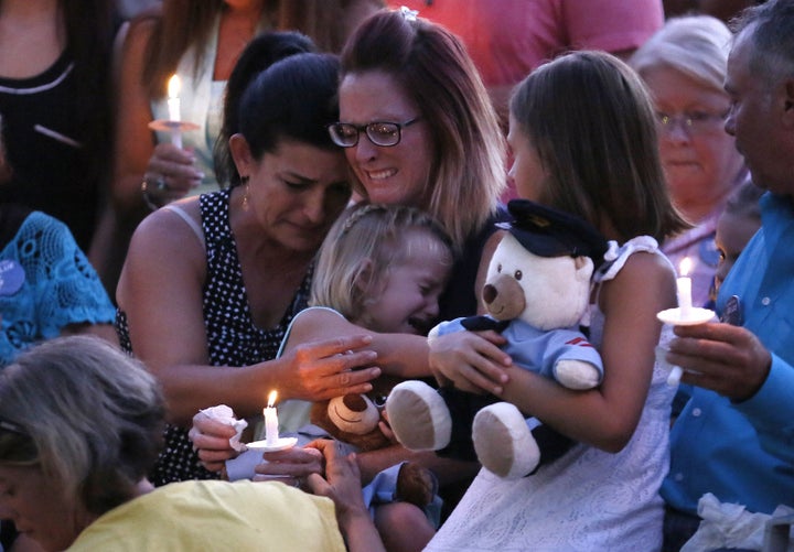 Dechia Gerald, wife of slain officer Matthew Gerald, holds her two daughters at a vigil in Baton Rouge, Louisiana, U.S. July 18, 2016.